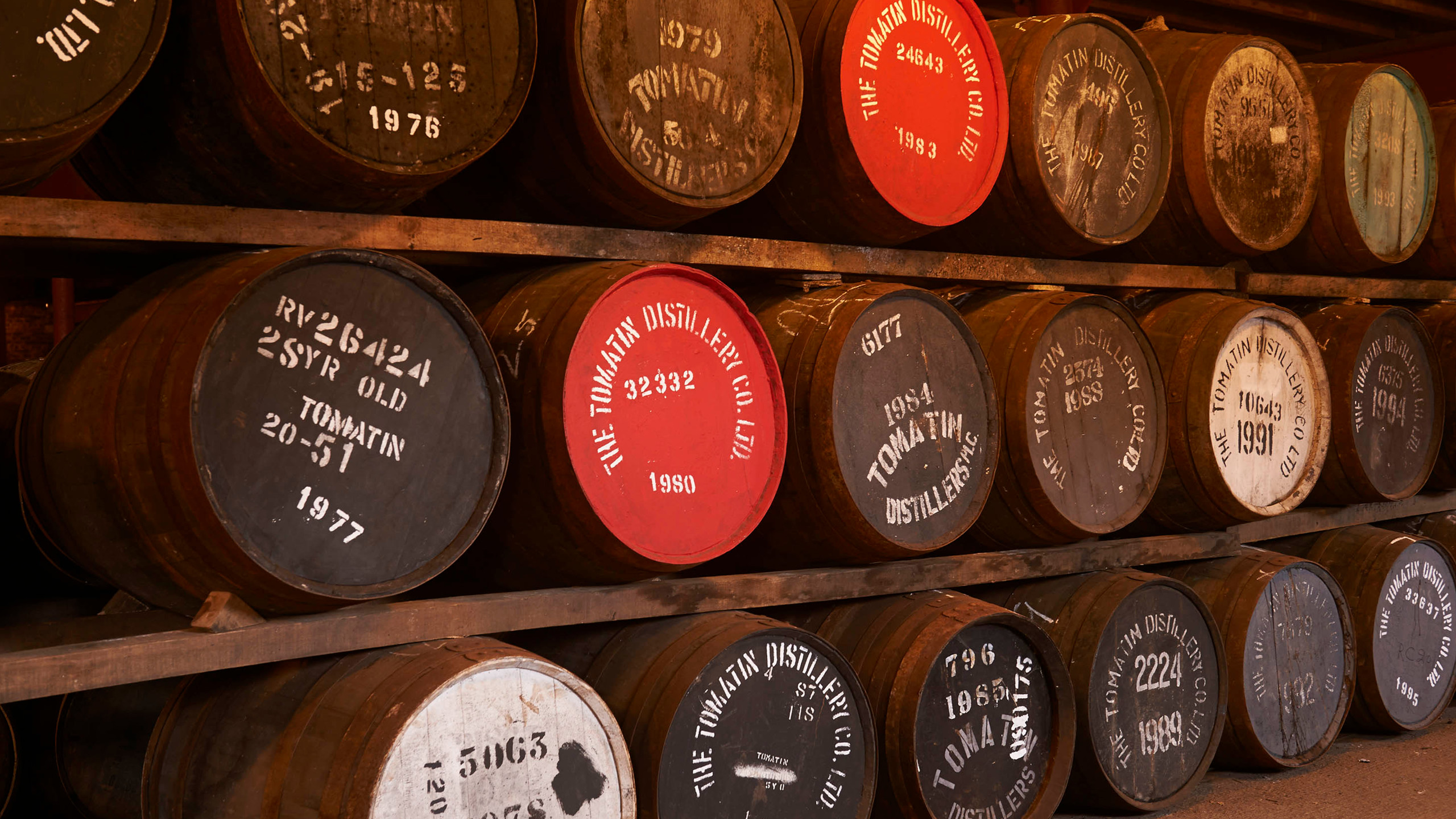 A wall of whisky aging barrels